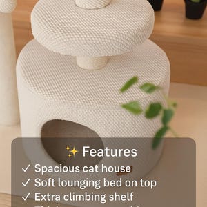 May include: A cream-coloured cat tree with a multi-tiered design. It includes a cat house, a soft lounging bed, and a climbing shelf. There's a thick cotton scratching post and a hanging pom-pom toy. The design is handmade and stable.