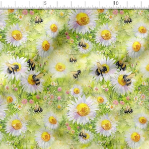 Può includere: Un disegno di tessuto in stile acquerello con margherite bianche con centri gialli e bombi neri e gialli. Lo sfondo è verde tenue con accenni di fiori rosa, creando un motivo floreale naturale.