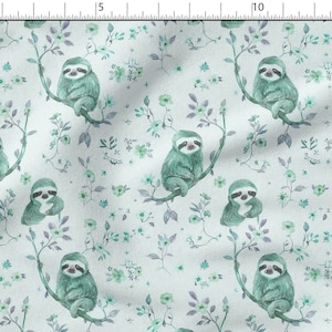 May include: Fabric with a repeating pattern of teal sloths perched on branches with green and purple floral accents. The sloths have a watercolor style and are set against a light blue background.