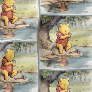 May include: A repeating pattern featuring Winnie the Pooh, in a red striped shirt, sitting by a stream and holding a cup. The background includes a tree, water, and a light blue border.