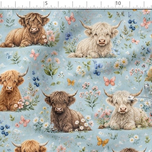 Peut inclure: Tissu bleu clair avec un motif répétitif de veaux Highland bruns et crème se reposant parmi des fleurs sauvages, des marguerites et des papillons. Une épingle à nourrice en métal est fixée sur le tissu, qui mesure 38 cm de large.