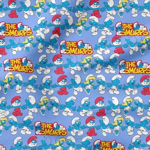 May include: A light blue fabric with a repeating pattern of Smurfs characters. The Smurfs are shown in different poses, with their blue skin, white trousers, and red or yellow hats. The text "THE SMURFS" is also visible.