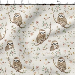 May include: Fabric with a repeating pattern of sloths perched on branches among small pink and yellow flowers. The sloths are light brown with dark eyes and claws. The background is a cream color.