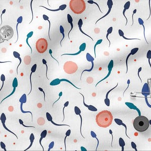 Peut inclure: Tissu blanc avec un motif répété de formes bleues et turquoise en forme de spermatozoïdes, de cercles roses et de points rouges. Épingles de sûreté argentées, une pièce de monnaie et un petit objet noir.