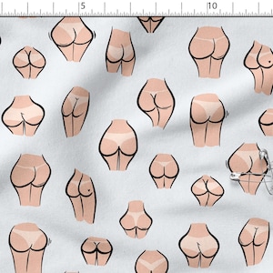 May include: White fabric with a repeating pattern of cartoon buttocks in various poses. The illustrations are in shades of peach and brown, with black outlines and some wearing white underwear. A silver safety pin is also visible.