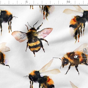 Könnte beinhalten: Weißer Stoff mit einem sich wiederholenden Muster aus Aquarell-Hummeln. Die Bienen sind in Schwarz-, Orange- und Gelbtönen dargestellt, mit zarten Flügeln. Das Design eignet sich für verschiedene Bastelprojekte, darunter Quilten und Bekleidung.