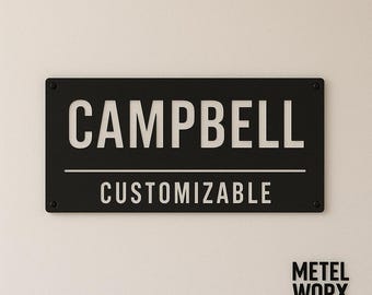 May include: Black metal sign with the name "CAMPBELL" in white lettering and the word "CUSTOMIZABLE" in white lettering below. The sign is on a white wall.