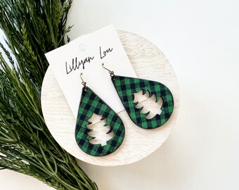 May include: Green and black plaid teardrop shaped earrings with a cut-out Christmas tree design. The earrings are on a white background with a card that says "Lillyann Lou".