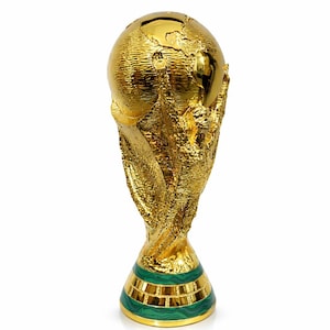 Könnte beinhalten: Goldene Trophäe mit einem Globus an der Spitze, gehalten von zwei Figuren. Der Sockel ist grün mit goldenen Akzenten. Symbol für Sieg und sportliche Leistung.