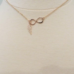 Pu&ograve; includere: Una collana d'oro con un ciondolo a forma di infinito e un ciondolo a forma di ala.