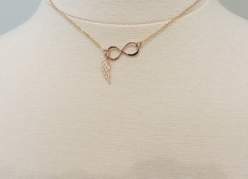 Pu&ograve; includere: Una collana d'oro con un ciondolo a forma di infinito e un ciondolo a forma di ala.