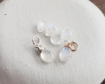 Puede incluir: Una colección de seis cuentas de piedra lunar blanca en forma de lágrima, algunas envueltas en alambre dorado y otras en alambre plateado.
