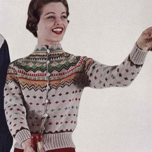 Puede incluir: Un cárdigan gris claro con un patrón geométrico colorido y cierre de botones. El cárdigan tiene un cuello alto y un dobladillo de canalé.