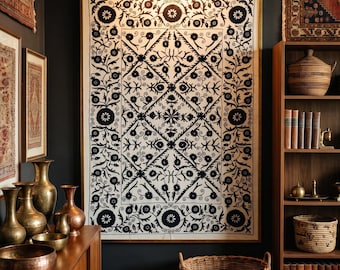 May include: A large rectangular wall hanging featuring a black floral and geometric pattern on a white fabric background, framed in gold. The design includes repeating diamond shapes, circular motifs, and intricate vine-like botanical elements.
