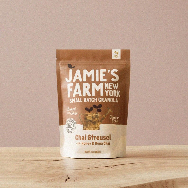 May include: A brown and white bag of Jamie's Farm New York Chai Streusel granola. The bag features the text "Small Batch Granola", "Baked with Ghee", and "Gluten Free". The net weight is 8 oz (226.8g).