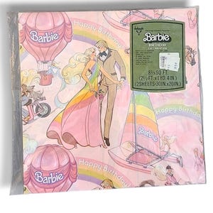 May include: Pink Barbie birthday gift wrap featuring a couple, hot air balloons, sailboats, and rainbows. The package includes two sheets, each measuring 30 inches by 20 inches.