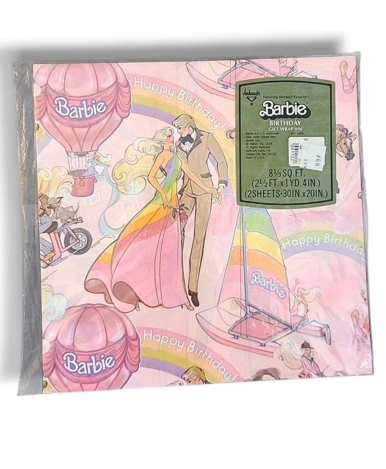 May include: Pink Barbie birthday gift wrap featuring a couple, hot air balloons, sailboats, and rainbows. The package includes two sheets, each measuring 30 inches by 20 inches.