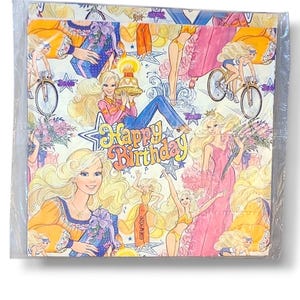 May include: A package of vintage napkins featuring a repeating pattern of a blonde woman in various poses, including riding a bicycle and holding a cake. The words "Happy Birthday" are in the center of the design. The napkins are in a clear plastic wrapper.