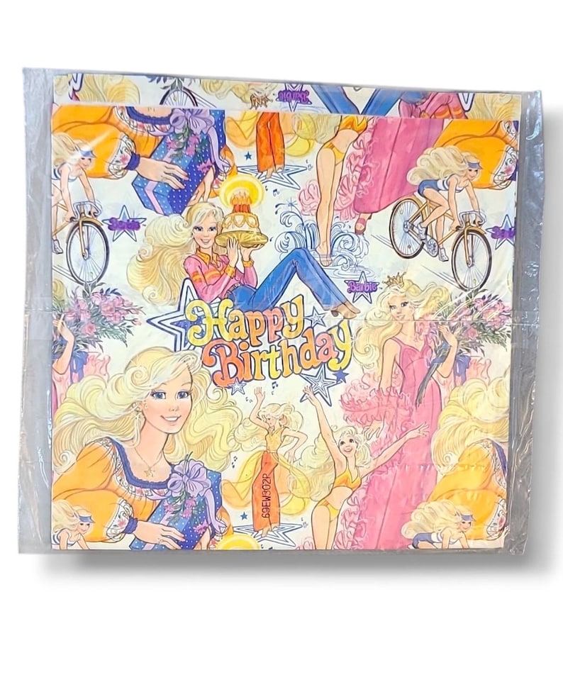 May include: A package of vintage napkins featuring a repeating pattern of a blonde woman in various poses, including riding a bicycle and holding a cake. The words "Happy Birthday" are in the center of the design. The napkins are in a clear plastic wrapper.