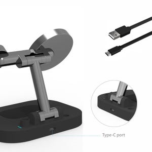May include: A black and silver phone stand with a Type-C port. The stand has a circular silver top and a black base. A black USB cable is also included.