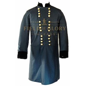 Może przedstawiać: Granatowy płaszcz wojskowy ze złotymi guzikami i czarnymi aksamitnymi mankietami. Płaszcz ma wysoki kołnierz i jest dwurzędowy. Na płaszczu wydrukowano napis "FIELD OF GLORY THREADS".