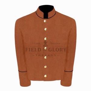 Peut inclure: Veste marron avec col et bordures noirs, boutons dorés sur le devant. La veste a des manches longues et le texte "FIELD & GLORY THREADS" est visible sur le devant.
