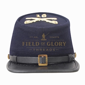 Puede incluir: Un kepi azul marino con visera y barboquejo de cuero negro. El sombrero presenta sables cruzados dorados y el número 16 en la corona. El texto "FIELD OF GLORY THREADS" está impreso en la parte delantera.
