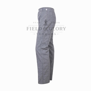 Puede incluir: Pantalones de lana grises con diseño de pierna recta. Los pantalones tienen cierre de botón y un aspecto clásico y a medida. El logotipo de Field of Glory Threads es visible en el fondo.