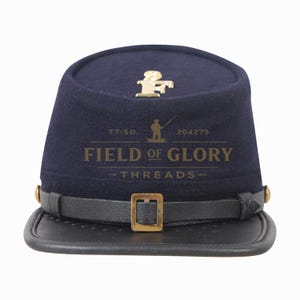 Puede incluir: Un kepi azul marino de la Guerra Civil con visera y correa de cuero negro. El sombrero presenta un emblema y una hebilla dorados. El texto "FIELD OF GLORY THREADS" está impreso en la parte delantera.