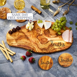 May include: A wooden serving board with the text "the Smiths est. 2026" and two matching coasters. The board holds cheese, grapes, strawberries, and chocolate. Two glasses of wine and a bottle of wine are also present.