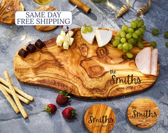 May include: A wooden serving board with the text "the Smiths est. 2026" and two matching coasters. The board holds cheese, grapes, strawberries, and chocolate. Two glasses of wine and a bottle of wine are also present.