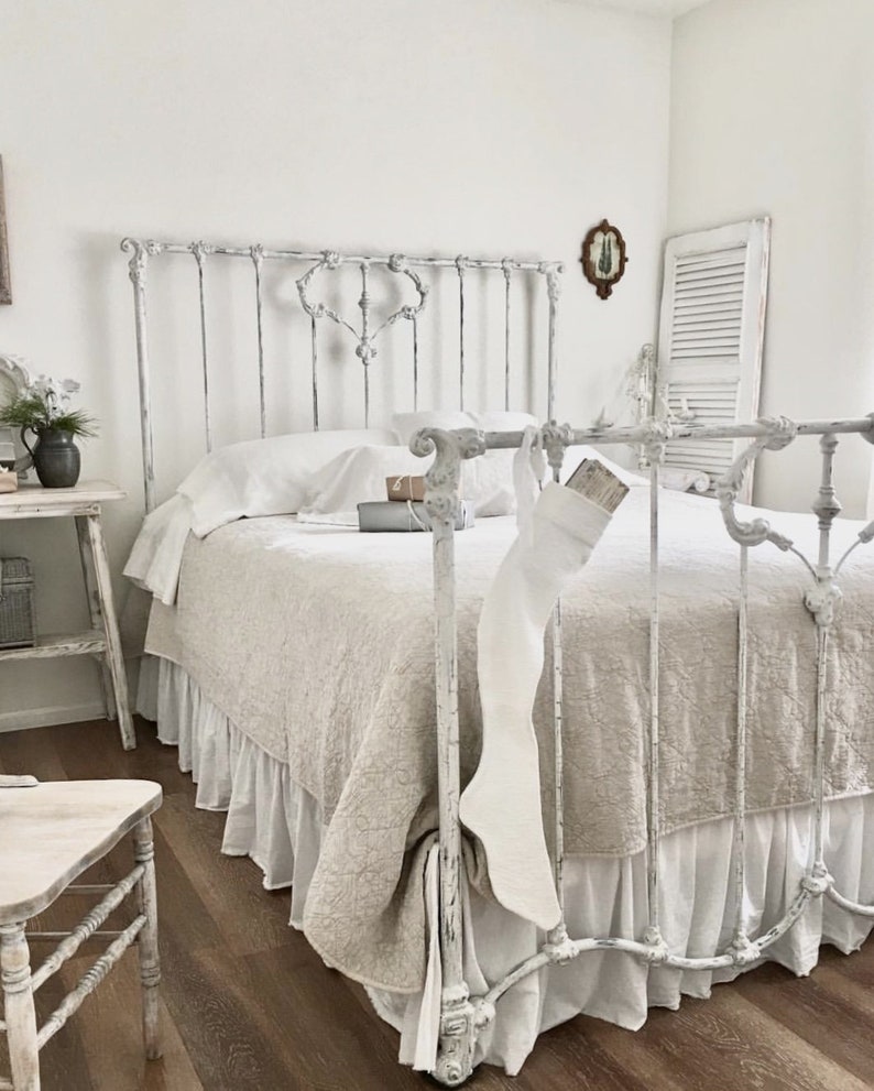 Christmas French White Stockings in a glorious tone on tone white French room with iron bed, wood floor, and neutral linens. #frenchcountry #bedroom #whitedecor #toneontone #nordicfrench #interiordesign