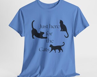 May include: A light blue t-shirt with the text "Just here for the Cats" and three black cat silhouettes. One cat is stretching, one is sitting, and one is walking.