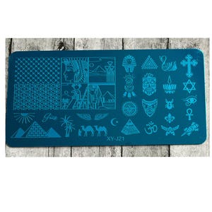 Peut inclure: Une plaque de stamping pour nail art de couleur teal avec divers motifs égyptiens et spirituels. La plaque présente des pyramides, des pharaons, des chameaux et d'autres symboles. Le texte "Giza" et "XY-J21" est également visible.