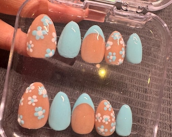 Uñas postizas hechas a mano con diseño de flor de almendro.