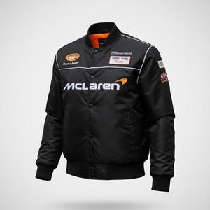 May include: A black bomber jacket featuring the McLaren logo in white and orange on the chest. The jacket includes a snap-button front closure, ribbed cuffs and hem, and various sponsor patches on the chest and sleeves with a bright orange interior lining.