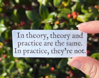 May include: A white rectangular sticker with the text "In theory, theory and practice are the same. In practice, they're not." The sticker is held against a background of green leaves and red berries.