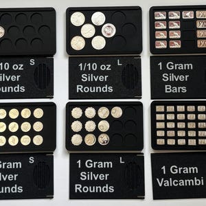 May include: Six black storage trays for precious metals. The trays are labeled 1/10 oz Silver Rounds S, 1/10 oz Silver Rounds L, 1 Gram Silver Bars, 1 Gram Silver Rounds S, 1 Gram Silver Rounds L, and 1 Gram Valcambi, containing various silver coins and bars.