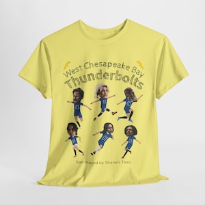 May include: Yellow t-shirt featuring a graphic of cartoon figures in blue uniforms, with the text "West Chesapeake Bay Thunderbolts" and "Sponsored by Shane's Tires". The design includes lightning bolt graphics.