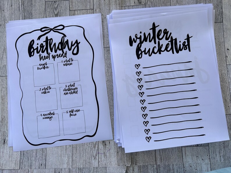 K&ouml;nnte beinhalten: Zwei druckbare Arbeitsbl&auml;tter, eines mit dem Titel "Birthday Tarot Spread" mit f&uuml;nf leeren K&auml;stchen und das andere mit dem Titel "Winter Bucketlist" mit einer Liste leerer Zeilen und Herzen.