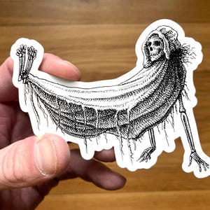 Peut inclure: Autocollant noir et blanc représentant une figure squelettique dans une cape à capuche, drapée sur une forme incurvée. L'illustration présente des hachures croisées détaillées et un thème macabre, avec les mains et les pieds osseux de la figure visibles.