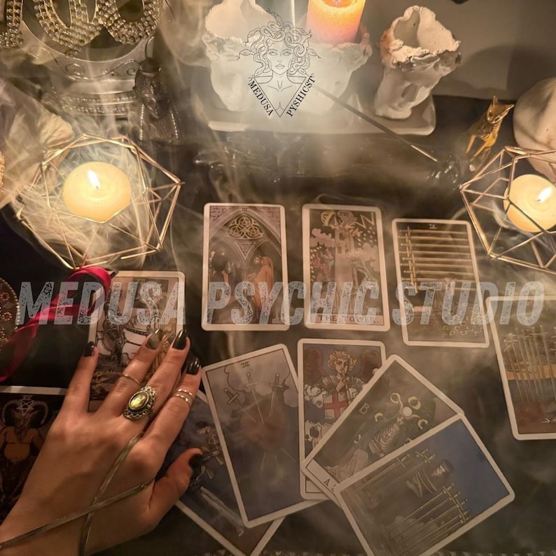 May include: A mystical scene featuring tarot cards laid out on a dark surface, with lit candles and decorative objects. The cards display detailed illustrations, and the text "MEDUSA PSYCHIC STUDIO" is visible. The scene evokes a sense of divination and spirituality.