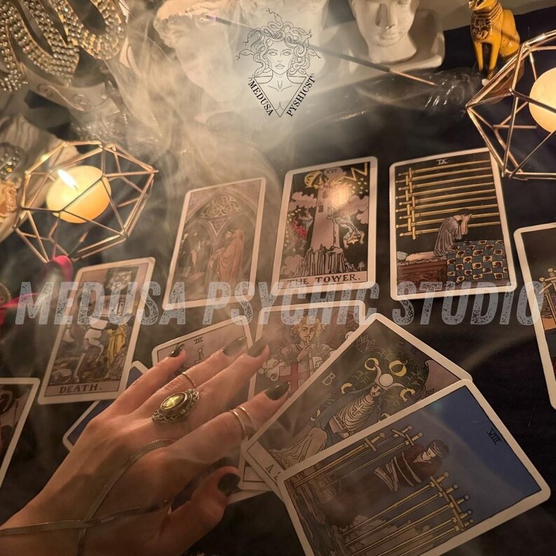 May include: A mystical scene featuring tarot cards, candles, and decorative objects. The cards are spread out, with the hand of a person visible, adorned with rings. The image has a dark, atmospheric aesthetic, with the text "MEDUSA PSYCHIC STUDIO" overlaid.