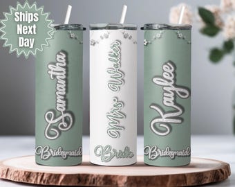 May include: Three personalized tumblers with straws. One is white with "Mrs. Walker Bride" and two are sage green with "Samantha Bridesmaid" and "Kaylee Bridesmaid" in script. Each tumbler has a floral design.