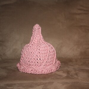 Puede incluir: Un gorro de punto de color rosa con una parte superior puntiaguda y un dise&ntilde;o texturizado.