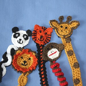 May include: Five crocheted animal bookmarks, including a panda, tiger, lion, monkey, and giraffe. Each bookmark features a different animal face and is made with colorful yarn.
