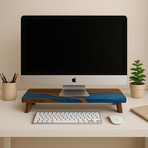 Puede incluir: Un soporte de monitor de madera con un diseño de río de resina azul. El soporte tiene forma rectangular con patas de madera y sostiene un monitor de ordenador, teclado y ratón. También se ven una pequeña maceta y un portalápices.