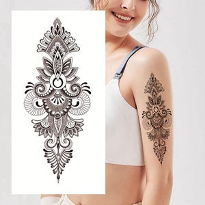 May include: Black and white temporary tattoo featuring an intricate floral design. The tattoo depicts a large, ornate flower with swirling patterns and leaves.