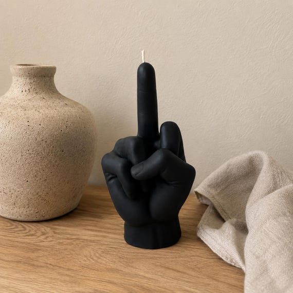 A hand-poured sculptural candle shaped like a raised middle finger — functional decor that says exactly what it needs to say.