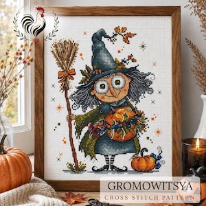 May include: A framed cross-stitch pattern titled GROMOWITSYA featuring a cartoon witch with a tall blue hat, gray hair, and a green cloak, holding a broom and a pumpkin. The design includes small orange stars and autumn foliage accents.